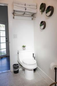 a white bathroom with a toilet and towels at Mid Century Modern - Walk to Dodger Stadium, DTLA in Los Angeles