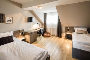 a hotel room with two beds and a desk at Bold Hotel Frankfurt Messe in Frankfurt