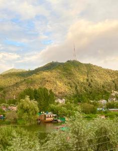 a boat on a river in front of a hill at Lake side stays in Srinagar