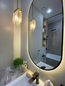 Un baño con un gran espejo y un lavabo. en Luxury Apartament, en Astana