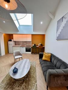 a living room with a couch and a table at Le Loft in Pont-de-Veyle