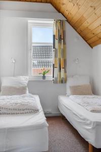 Dos camas en una habitación con ventana. en 0407-Romo-Vestergade-225-App-9, en Sønderby