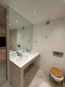 un bagno con due lavandini e un grande specchio di Ferienhaus im Odenwald a Modautal