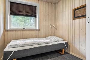 a bed sitting in a room with a window at 2601-Romo-Praestekraven-7 in Mølby