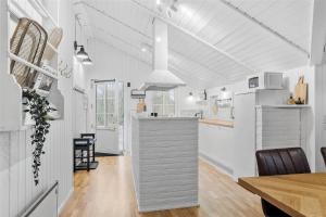 a kitchen and dining room with white walls and wood floors at 0155-Romo-Davidstraede-10-c in Kongsmark