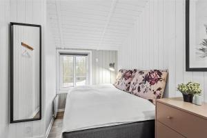 a white bedroom with a bed and a window at 0155-Romo-Davidstraede-10-c in Kongsmark
