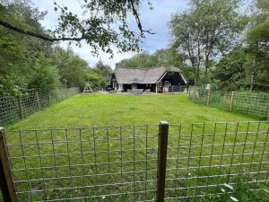 a barn in a field with a fence at 0155-Romo-Davidstraede-10-c in Kongsmark