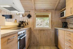 a kitchen with wooden walls and a window and a stove at 0011-Romo-Trinnesvej-9 in Bolilmark +13 photos