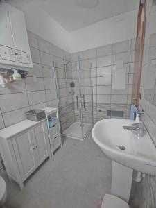 a white bathroom with a sink and a shower at Il campazzo locazione turistica in Motta di Livenza +3 photos