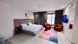 a bedroom with a bed and a chair at بلوم قاردن - Plum Garden in Taif