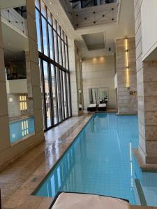 a large swimming pool in a building with windows at Michelangelo Towers 3Bed Apartment in Johannesburg