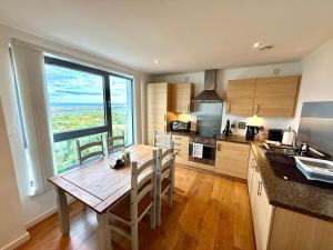 エディンバラにあるBritannia Ocean Park Apartments - Fast Wifi and Free Parkingのキッチン(木製テーブル付)、大きな窓が備わります。 +26枚の写真
