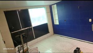 a room with a large window and blue walls at Apartamento Compacto in Ananindeua