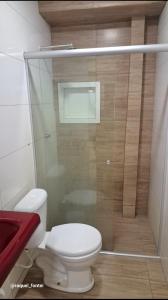 a bathroom with a toilet and a glass shower at Apartamento Compacto in Ananindeua
