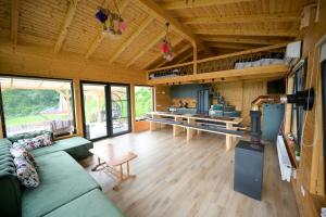a living room with a green couch and a kitchen at Montis House in Vişeu de Mijloc