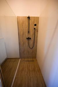 a shower in a room with a wooden floor at Montis House in Vişeu de Mijloc +7 photos
