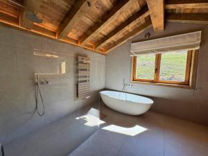 a bathroom with a white tub and a window at Chalet de Luxe pour 12 Pers. avec Sauna et Cinéma - FR-1-452-398 in Saint-Marcel