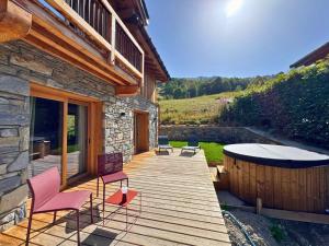 a wooden deck with chairs and a hot tub at Chalet de Luxe pour 12 Pers. avec Sauna et Cinéma - FR-1-452-398 in Saint-Marcel +11 photos