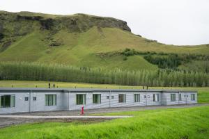 キルキュバイヤルクロイストゥルにあるAdventure Hotel Geirlandの背景に丘がある長い金属製の建物