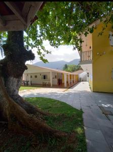 a large tree in front of a building at Novo Encanto in Ubatuba