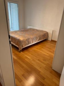 a bed in a room with a wooden floor at City Apartment in Opfikon
