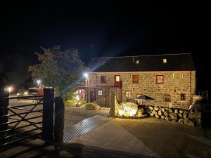 a stone barn at night with a fire place in front at Wee Henry's Barn in Ballymartin