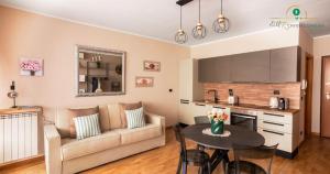 a living room with a couch and a table at Eur Crystal Garden - Loft moderno con Terrazza privata e Box auto in Rome