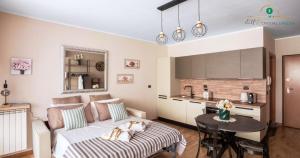 a living room with a couch and a table and a kitchen at Eur Crystal Garden - Loft moderno con Terrazza privata e Box auto in Rome