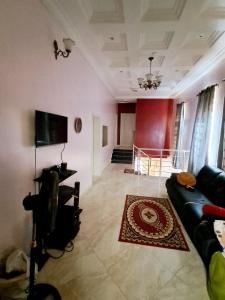 a living room with a couch and a television at Exquisite home in Lekki +24 photos
