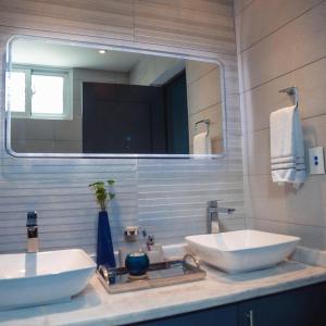 a bathroom with two sinks and a large mirror at RED HEART 3 BEDROOMS OCEAN VILLAGe in Puerto Plata +10 photos