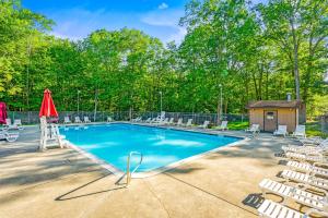 piscina con sedie e ombrellone rosso di Private Yard, Playset Family Home in Penn Estates a East Stroudsburg