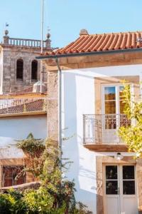 a white house with a balcony on the side of it at Quintal do Grémio - Casa in Torre de Moncorvo