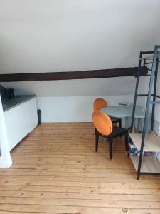 a room with a table and a chair and a bunk bed at Logement atypique in Asnières-sur-Seine