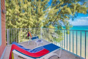 a bench on a balcony with a view of the ocean at Cayman Paradise Villa #1 in Old Isaacs +65 photos