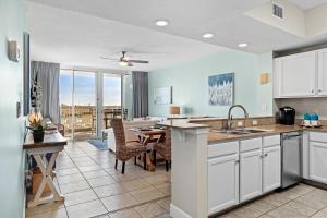フォート・ウォルトン・ビーチにあるWaters Edge 109 - Ground Floor and Beach Front - Steps to Pool and Sand - Free Beach Svcのテーブルとダイニングルームのあるキッチン