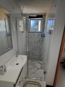 um banheiro branco com chuveiro e pia em casa Moderna com Ar do Campo em Contagem mais 23 fotografias