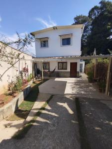 Uma casa branca com uma entrada à frente. em casa Moderna com Ar do Campo em Contagem