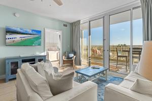 フォート・ウォルトン・ビーチにあるWaters Edge 109 - Ground Floor and Beach Front - Steps to Pool and Sand - Free Beach Svcのリビングルーム(白い家具付)が備わり、ビーチの景色を望めます。