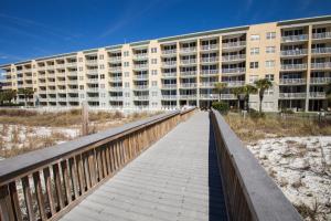 フォート・ウォルトン・ビーチにあるWaters Edge 109 - Ground Floor and Beach Front - Steps to Pool and Sand - Free Beach Svcの大きなアパートメントビルにつながる遊歩道