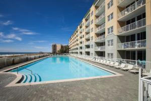フォート・ウォルトン・ビーチにあるWaters Edge 109 - Ground Floor and Beach Front - Steps to Pool and Sand - Free Beach Svcのビーチ付きの建物の前にあるスイミングプール