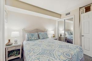 une chambre avec un lit et un miroir dans l'établissement Plantation Palms #6208, à Gulf Highlands 33 autres photos