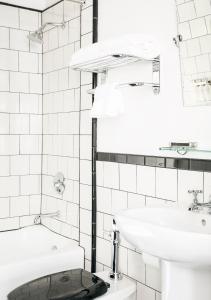 a white bathroom with a toilet and a sink at Tilden Hotel in San Francisco