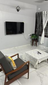a living room with a couch and a bed and a flat screen tv at Geethanjali Homes in Kanyakumari