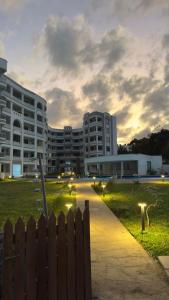 a building with a fence in front of a park at The Nest at Baobab Waves in Mombasa