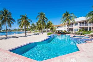 a resort pool with palm trees and a building at Korner Kai Condo in Driftwood Village +45 photos