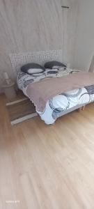 a bed in a room with a wooden floor at Appartement de 46M2 in Chasseneuil-du-Poitou