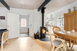 a kitchen with a table and a wood stove at 0496-Romo-Norre-Frankel-9 in Havneby