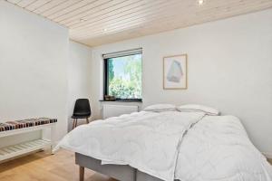 - une chambre blanche avec un lit et un piano dans l'établissement 2701-Romo-Klitvejen-18, à Sønderby
