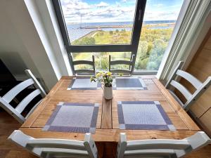 エディンバラにあるBritannia Ocean Park Apartments - Fast Wifi and Free Parkingのダイニングテーブルと椅子、そして大きな窓