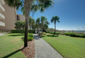 a park with palm trees and a sidewalk at Waters Edge 603 - Direct Ocean Views - Top Floor - Beach Service in Fort Walton Beach